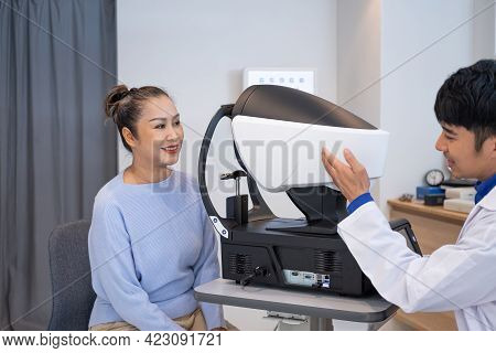 Doctor Using Penlight And Optometry Frame Equipment And Do Subjective Refraction To  Examine Eye Vis