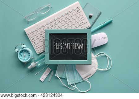 Presenteeism Term Written On Blackboard. Flat Lay In Monochrome Mint Blue Hues. Office Supplies, Key