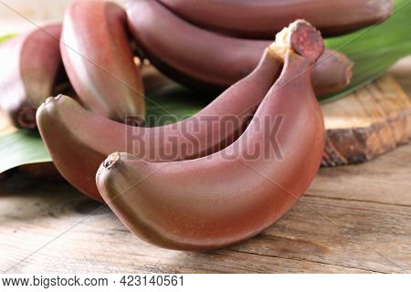 Delicious Red Baby Bananas On Wooden Table, Closeup