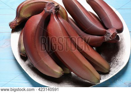 Tasty Red Baby Bananas On Light Blue Table, Closeup