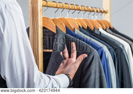 Male Suits Hanging In A Row. Men Clothing, Boutiques. Man Suit, Tailor In His Workshop. Fashion Man 
