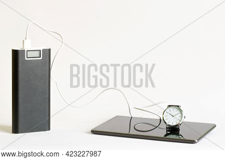 Large Capacious External Battery - Power Bank Next To A Charged Gadget - Smartphone Or Tablet And  W