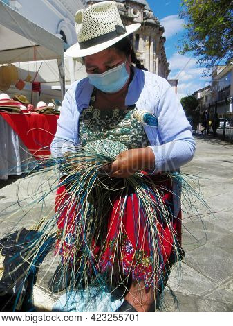 Cuenca, Ecuador - June 9, 2021: Indigenous Woman Demonstrates Tradition Weaving Of Panama Hat Or Paj