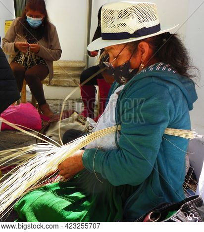 Cuenca, Ecuador - June 9, 2021: Indigenous Woman Demonstrates Tradition Weaving Of Panama Hat Or Paj