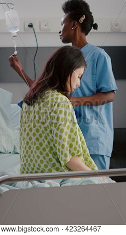 Afro American Asisstant Monitoring Hospitalized Sick Woman With Respiratory Illness Recovering After