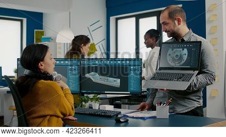 Engineer Holding Laptop And Pointing On Display Showing To Manager 3d Gears Image Working In Cad Pro