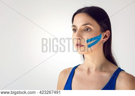 Portrait Of A Young Woman With Pasted Konesiotape For Rejuvenation And Face Tightening