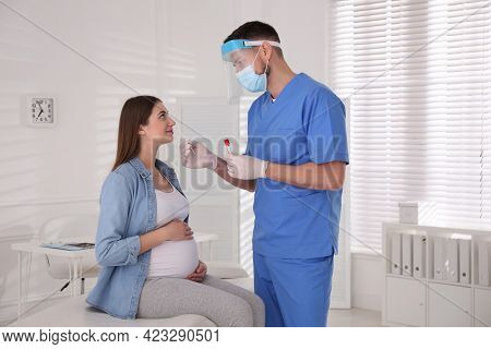 Doctor Taking Nasal Smear Of Pregnant Woman For Coronavirus Test In Clinic