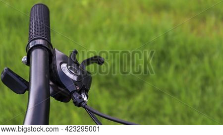 Mountain Bike Steering Wheel On Green Grass Background. Details Of Sporting Events. Close Up Black M