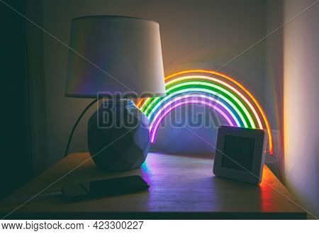 Glowing led neon rainbow on the side table in the evening