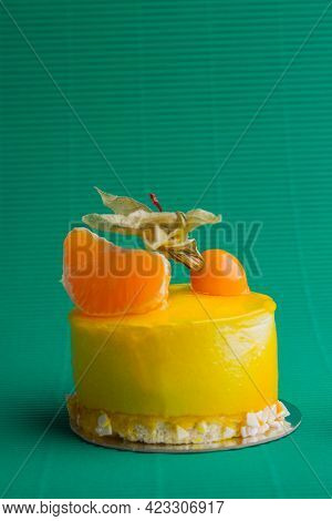 Sweet Yellow Cupcake With Peeled Mandaring On Green Background.