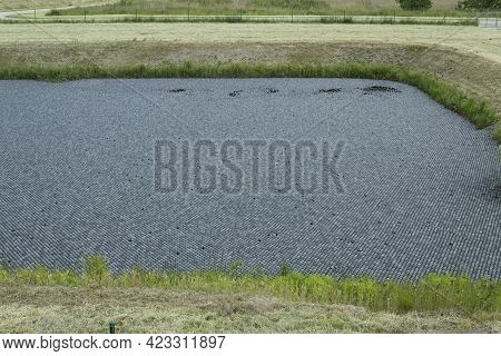 Black Balls To Protect Reservoirs From The Sun. Shade Balls, Small Plastic Balls In The Pond To Keep