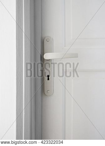 Knob And Handle Detail On Exterior White Door. White Lock On Closed Gate. Classic Doorhandle On Clos