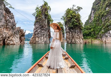 Happy Young Female Tourist In Dress And Hat At Longtail Boat Near Famous Three Rocks With Limestone 