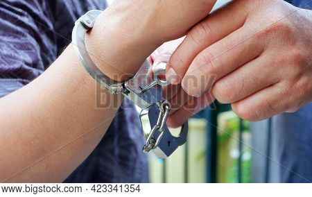Close Up Police Staff's Hands Unlocking Handcuffs On Male Accused Hand By Key, Focus On Key Handcuff