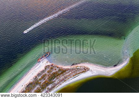 Old shipwreck reinforced concrete barge abandoned stand on beach on the coast of Black sea in Kinburn peninsula, Ukraine
