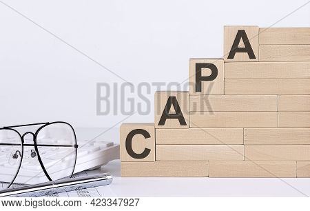 Wooden Cubes With Letters Capa On White Table With Keyboard And Glasses