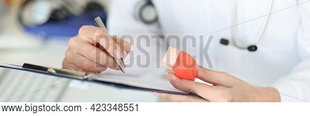 Pulmonologist Holding Inhaler In Hands And Writing In Documents Closeup