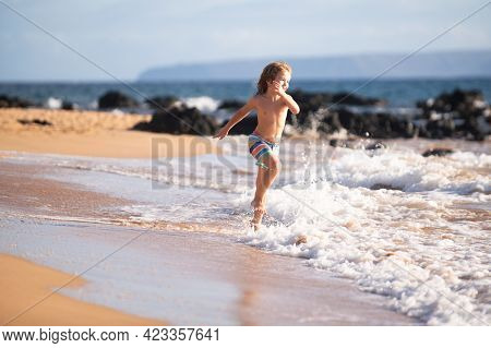 Child Running Through Water Close To Shore Along The Sea Beach. A Boy Runs Along The Sea Coast. Rest