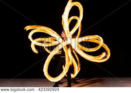 Sexy Woman Artist Perform Fiery Twirly Trails By Spinning Flaming Pois During Fire Performance
