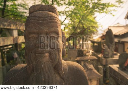 Head Shot Of A Wise Man Stone Statue In Asian Style. Statue In Buddhist Graveyard In The Complex Of 