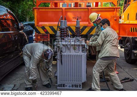 Nonthaburi, Thailand- May 19, 2021: Electrical Wireman Are  Installing Cable To The Transformer For 