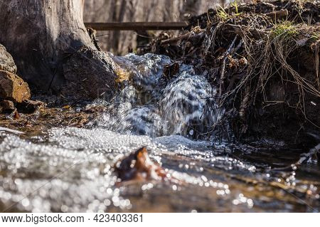 A Beautiful Small Waterfall In The Forest, The Water Flows Rapidly Over The Stones. A Streamlet In T