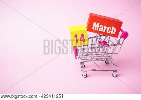 March 14th. Day 14 Of Month, Calendar Date. Close Up Toy Metal Shopping Cart With Red And Yellow Box