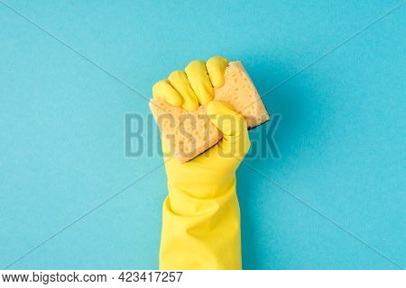 Top View Photo Of Raised Hand In Yellow Rubber Glove Clenching Yellow Scouring Pad On Isolated Paste