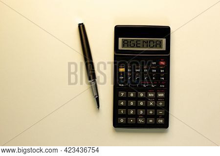 Agenda Symbol. Calculator With The Concept Word 'agenda', Metalic Pen. Business And Agenda Concept. 