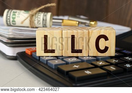 Finance And Economics Concept. On The Table Are Money, A Calculator, A Notebook And Cubes With The I