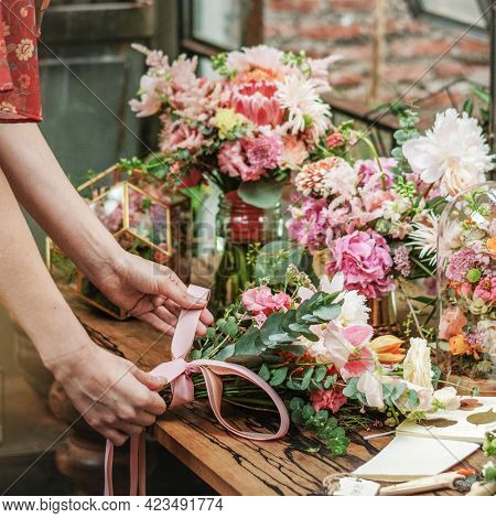 Florist tying a ribbon on a bouquet