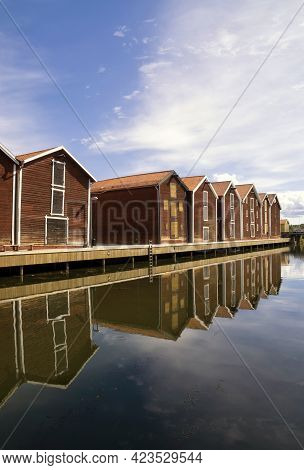 Wooden Houses Reflecting In The Harbour In Hudiksvall
