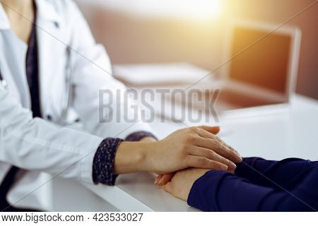 Unknown Woman-doctor Is Holding Her Patients Hands, Discussing Current Health Examination, While The
