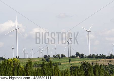 Rear View Man Engineer Wearing Personal Protective Equipment Working In Wind Turbine Farm Background