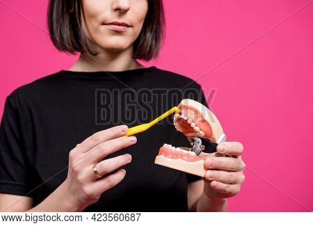 Beautiful Happy Young Woman With Single Tufted Toothbrush On Blank Pink Background