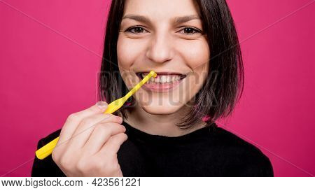 Beautiful Happy Young Woman With Single Tufted Toothbrush On Blank Pink Background