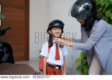 Mother Taking Her Daughter To School By Motorcycle In The Morning