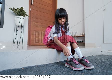 Primary Student Preparing To Go To School In The Morning