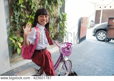 Girl Primary Student Going To School By Riding A Bike In The Morning