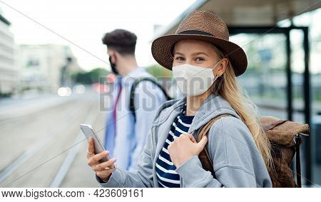 Young Woman Tourist Traveler On Holiday Waiting At The Bus Stop In City, Coronavirus Concept.