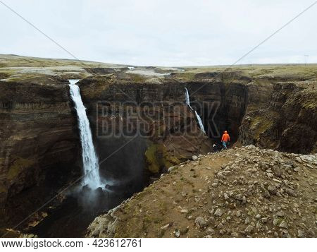 Drone shot of a man at the Haifoss waterfall, Iceland