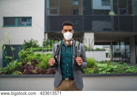 Portrait Of Cheerful Young Man With Face Mask Looking At Camera Outdoors In City, Covid-19 Concept.