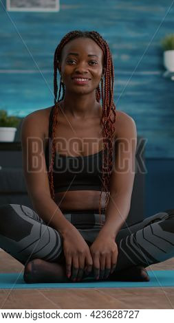 Portrait Of Black Athlete Sitting In Lotus Position On Floor Enjoying Morning Workout In Living Room