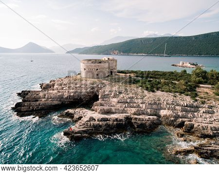 Man And Woman In Love Stand Embracing On The Rocky Seashore Near Arza Fortress