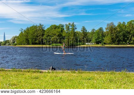 Unrecognizable Young Woman In A Bikini On A Sup Board  With A Paddle On A Picturesque River Overlook