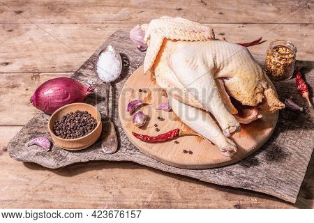 Raw Whole Chicken Carcass For Healthy Food Lifestyle With Red Onion, Garlic Cloves, Spices, And Sea