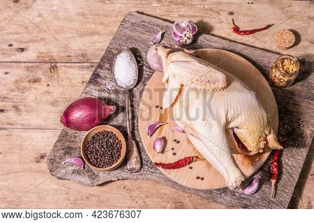 Raw Whole Chicken Carcass For Healthy Food Lifestyle With Red Onion, Garlic Cloves, Spices, And Sea
