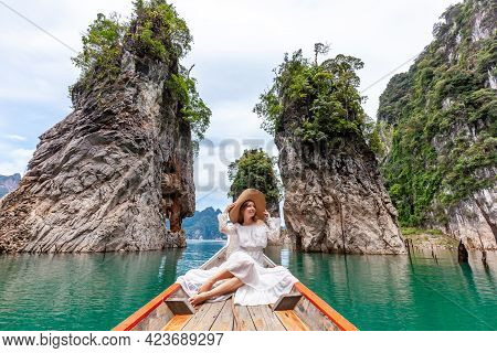 Young Female Tourist In Dress And Hat At Longtail Boat Near Famous Three Rocks With Limestone Cliffs