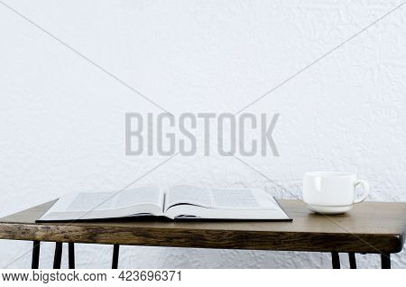 Open Book Holy Bible On A Wooden Table. A Cup Of Coffee.